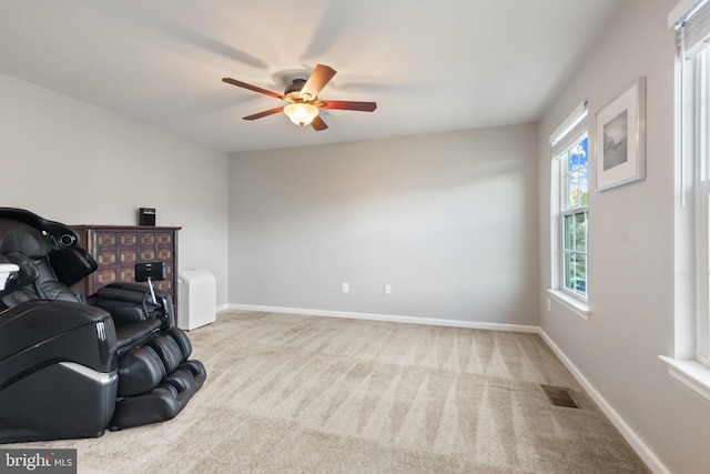 living area with ceiling fan and light colored carpet