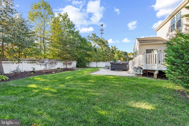 view of yard featuring a patio area, a wooden deck, and a hot tub