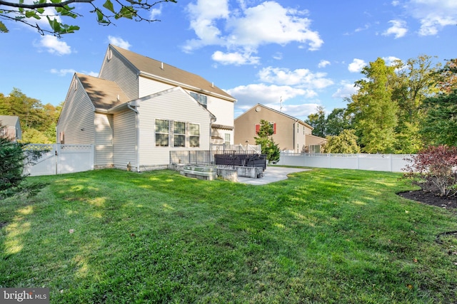 back of property with a patio area and a yard