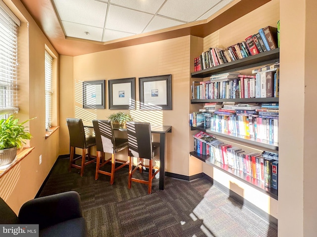 sitting room featuring a paneled ceiling and dark carpet