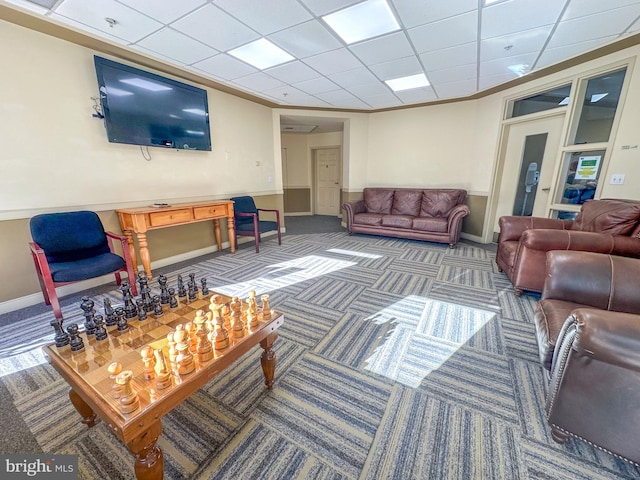 living room featuring a drop ceiling and carpet flooring