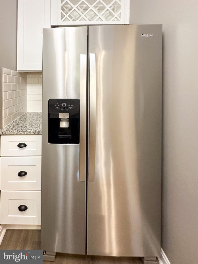 details with white cabinets, tasteful backsplash, stainless steel fridge with ice dispenser, light stone countertops, and dark hardwood / wood-style flooring