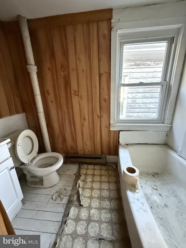 bathroom with a tub to relax in, vanity, and toilet