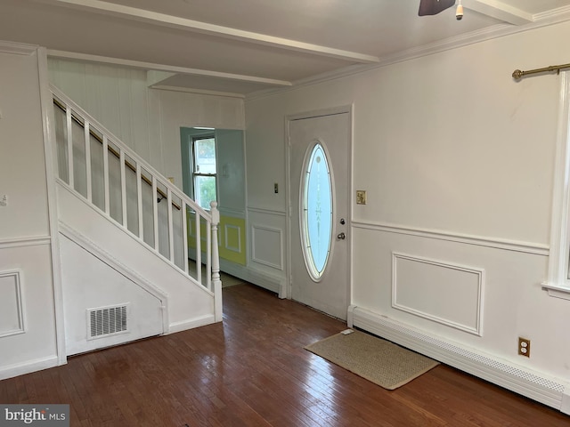 entrance foyer featuring dark hardwood / wood-style floors, ceiling fan, ornamental molding, baseboard heating, and beamed ceiling