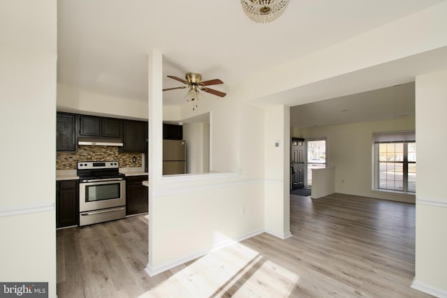 kitchen featuring light wood-type flooring, appliances with stainless steel finishes, decorative backsplash, and ceiling fan