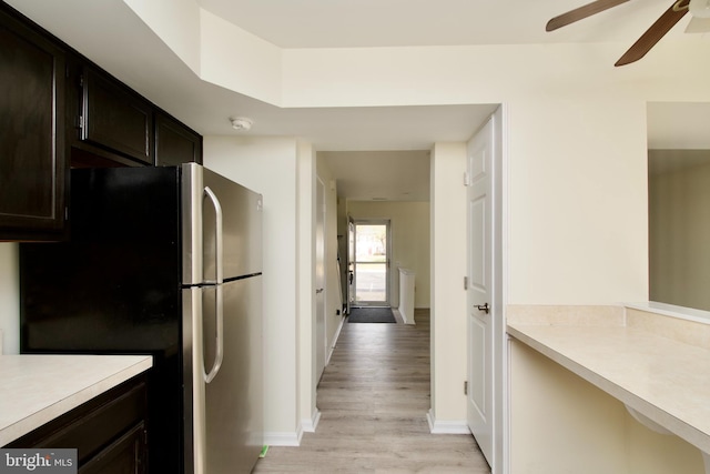 kitchen featuring dark brown cabinetry, stainless steel fridge, light hardwood / wood-style flooring, and ceiling fan