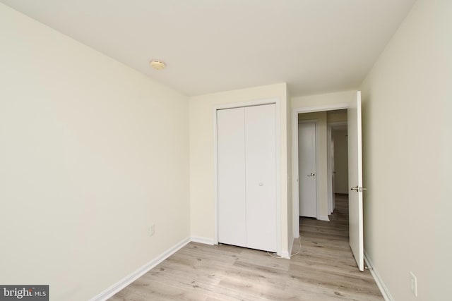 unfurnished bedroom with a closet and light hardwood / wood-style floors