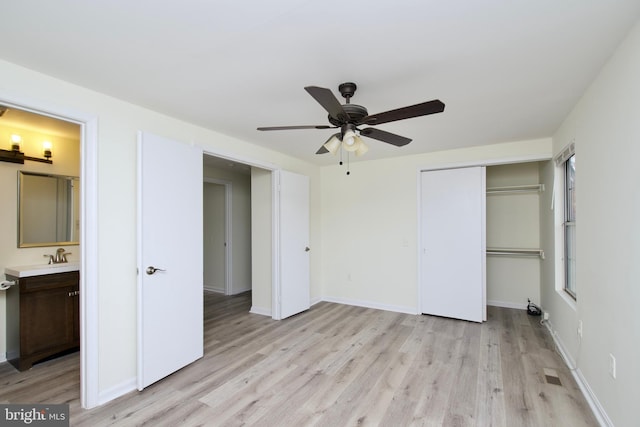 unfurnished bedroom with light wood-type flooring, sink, ceiling fan, and ensuite bath