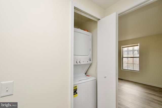 washroom featuring stacked washer and dryer and light hardwood / wood-style floors