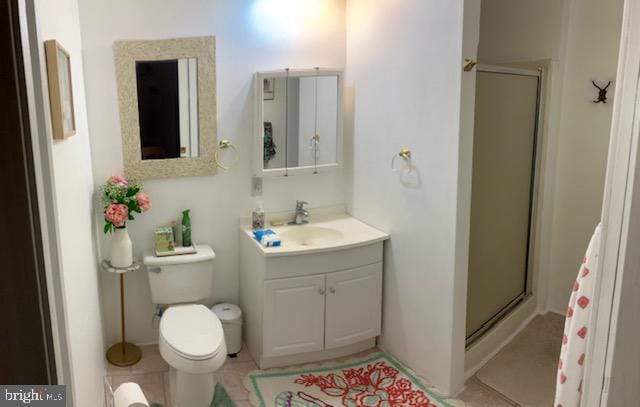 bathroom with vanity, toilet, tile patterned floors, and a shower with shower door