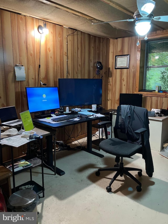 home office with wooden walls and concrete flooring