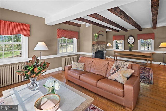 living room with beam ceiling, wood-type flooring, and radiator heating unit