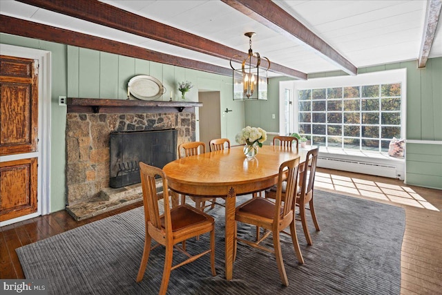 dining area with a stone fireplace, dark hardwood / wood-style floors, beam ceiling, a baseboard heating unit, and an inviting chandelier