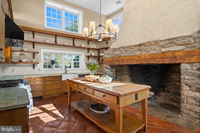 kitchen featuring exhaust hood, sink, hanging light fixtures, and a wealth of natural light