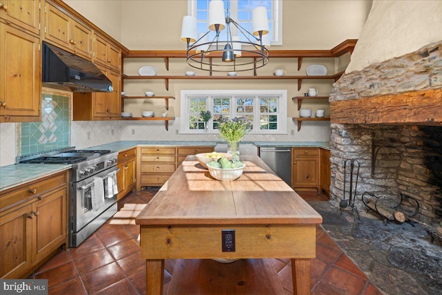 kitchen with appliances with stainless steel finishes, a notable chandelier, decorative backsplash, and a kitchen island