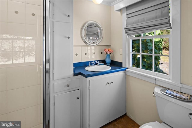 bathroom featuring toilet, crown molding, vanity, and tile patterned floors