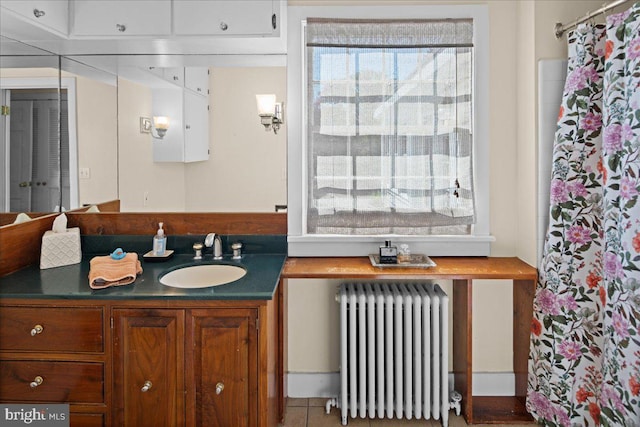 bathroom featuring radiator, tile patterned flooring, and vanity