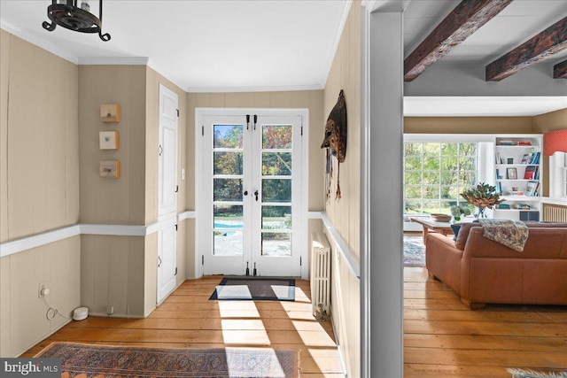 doorway featuring beamed ceiling, french doors, light wood-type flooring, and plenty of natural light