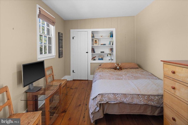 bedroom with dark hardwood / wood-style flooring