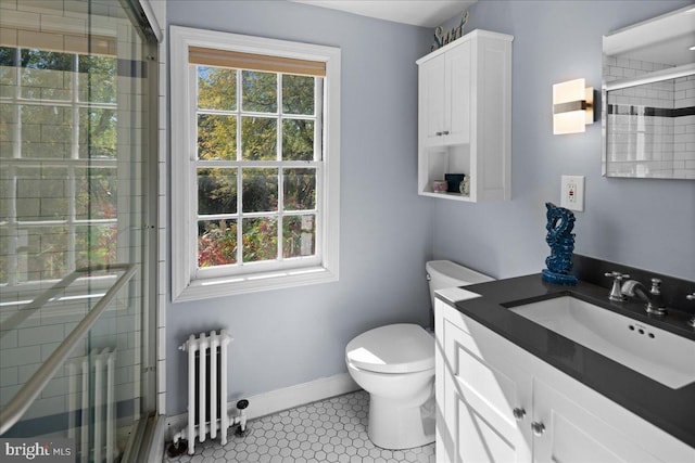 bathroom with radiator heating unit, toilet, vanity, an enclosed shower, and tile patterned flooring