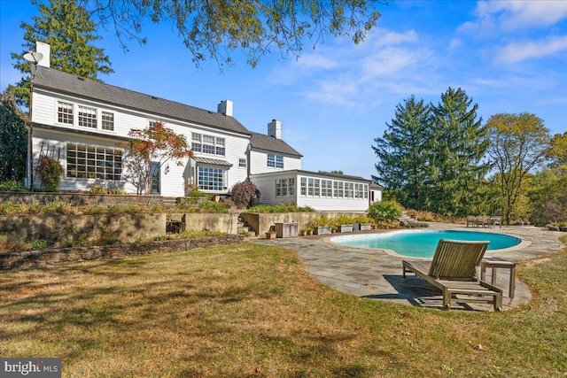 rear view of property featuring a patio and a lawn