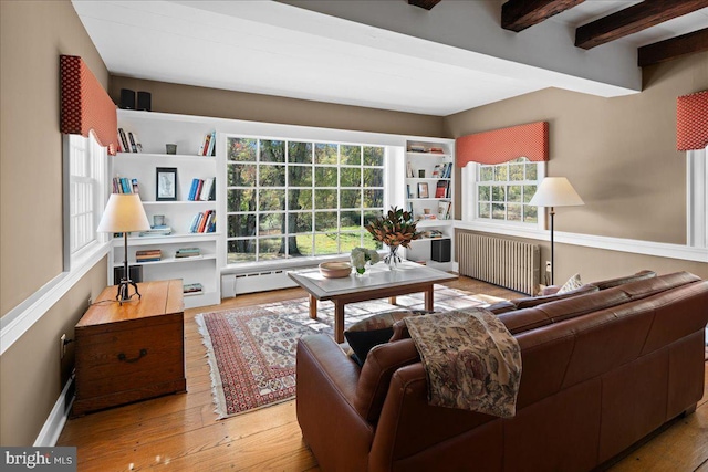 living room featuring beamed ceiling, radiator heating unit, light hardwood / wood-style floors, and a baseboard radiator