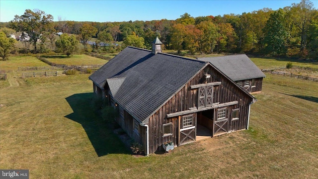 rear view of house featuring a yard and an outbuilding