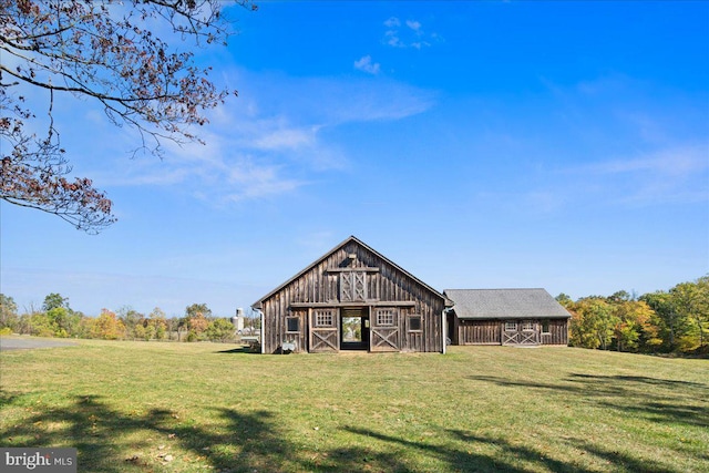 rear view of house with an outdoor structure and a yard