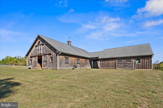 back of property with an outdoor structure and a lawn