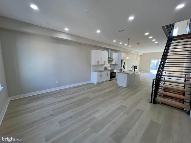 unfurnished living room featuring light wood-type flooring and sink