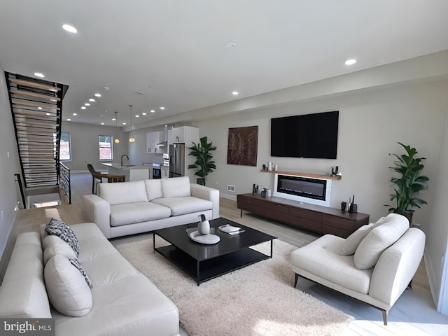 living room with light wood-type flooring and sink