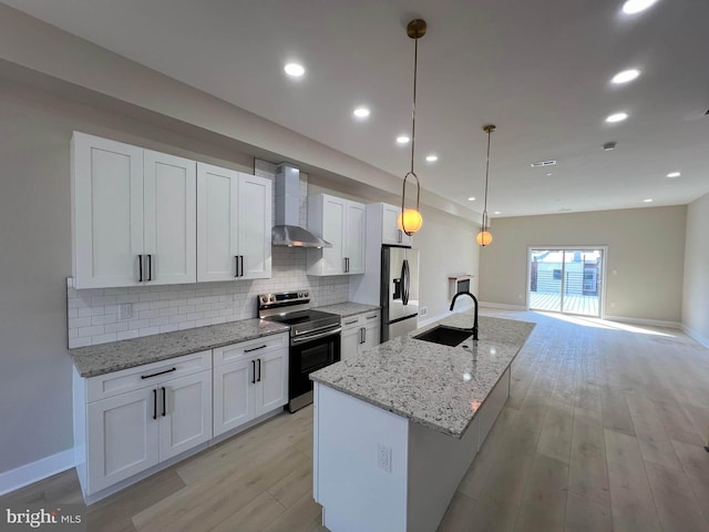 kitchen featuring wall chimney exhaust hood, stainless steel appliances, white cabinetry, and hanging light fixtures