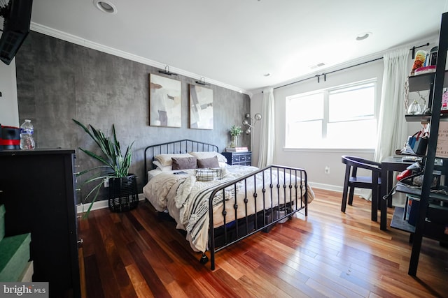 bedroom with ornamental molding and wood-type flooring