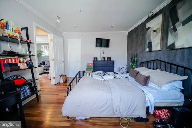 bedroom featuring ornamental molding and hardwood / wood-style flooring