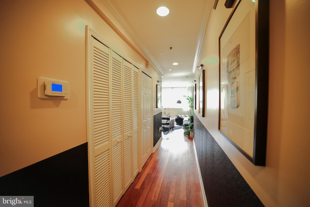 corridor with dark hardwood / wood-style floors and ornamental molding