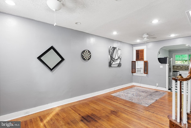 interior space with a textured ceiling, wood-type flooring, and ceiling fan