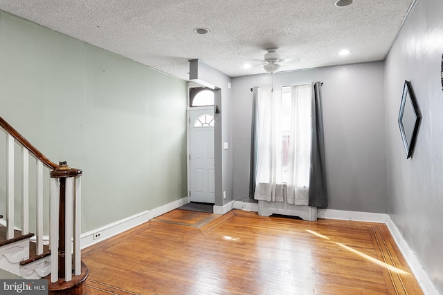 foyer entrance with a textured ceiling, hardwood / wood-style flooring, and ceiling fan