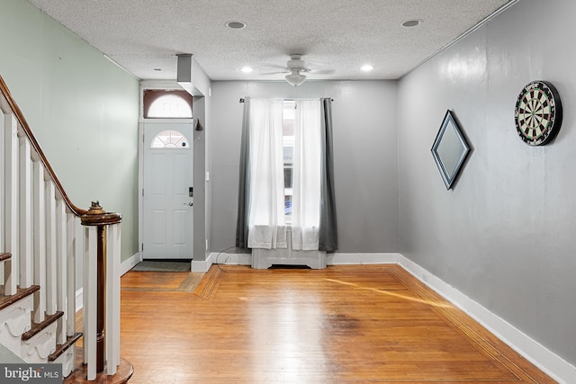 entrance foyer featuring ceiling fan, hardwood / wood-style flooring, and a textured ceiling