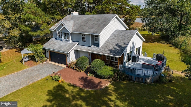 view of front of house with a garage, a front yard, and a wooden deck