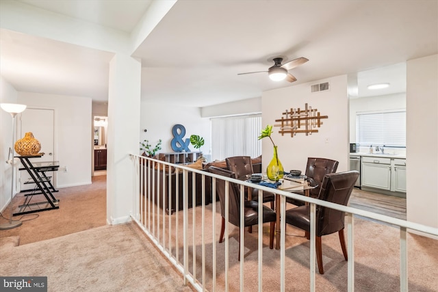 interior space featuring ceiling fan, sink, and light colored carpet