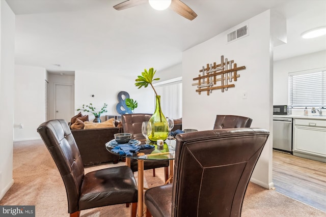 dining area featuring light hardwood / wood-style floors, sink, and ceiling fan