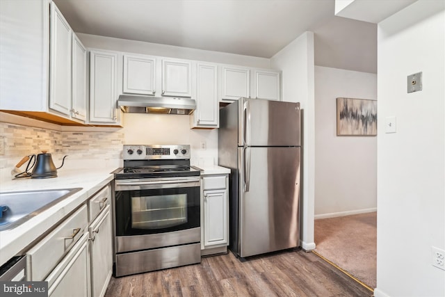 kitchen with appliances with stainless steel finishes, sink, white cabinetry, decorative backsplash, and dark hardwood / wood-style floors