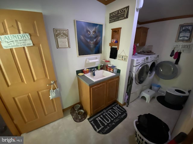 laundry room featuring ornamental molding, sink, independent washer and dryer, and cabinets