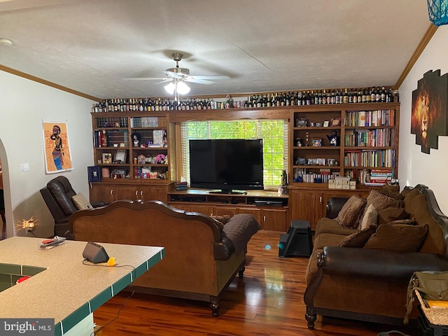 living room featuring a textured ceiling, ornamental molding, dark hardwood / wood-style floors, and ceiling fan