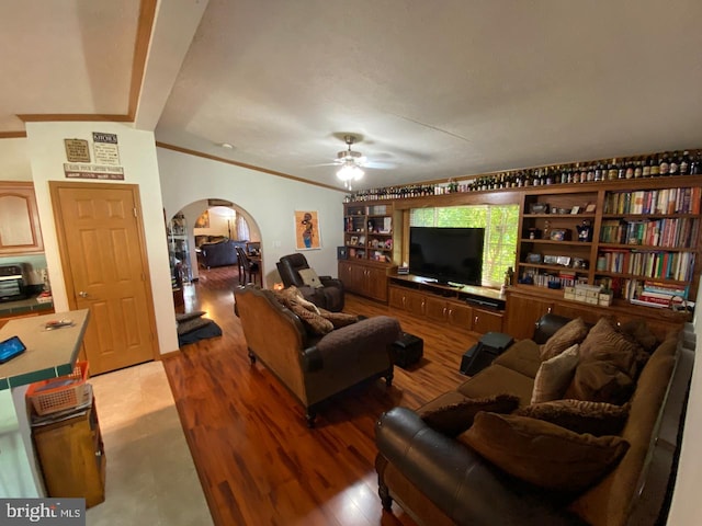 living room with ceiling fan, light hardwood / wood-style flooring, crown molding, and beam ceiling