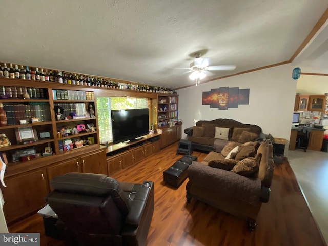 living room featuring a textured ceiling, wood-type flooring, ornamental molding, and ceiling fan