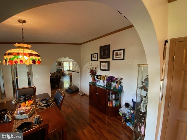 dining area with ornamental molding and dark hardwood / wood-style floors