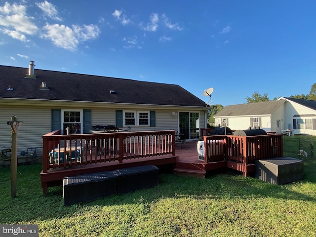 back of house with a wooden deck and a lawn