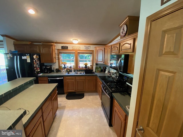 kitchen with ornamental molding, black appliances, vaulted ceiling, and sink