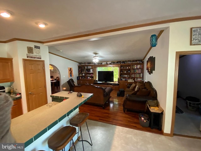 living room with ornamental molding, ceiling fan, and hardwood / wood-style floors